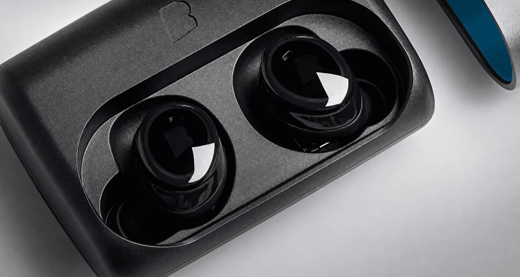 Close-up of Bragi Dash Pro earbuds in their charging case
